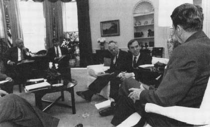 National Security briefing in the Oval Office with Oliver North at rear. (Courtesy, Ronald Reagan Library)