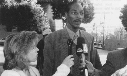 Rap singer Snoop Doggy Dogg talks with reporters as he arrives at the courthouse for his trial. (AP/Wide World Photos)