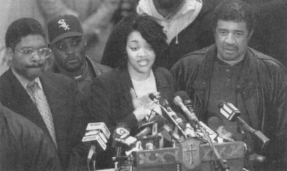 Tawana Brawley with Alton Maddox (left) speaks to supporters before the defamation lawsuit against the men who had advised her. (AP/Wide World Photos)